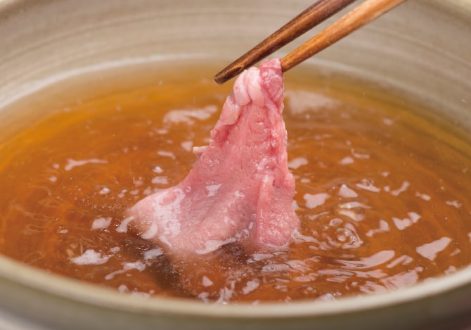 しゃぶしゃぶ用の牛たんを出汁にくぐらせる様子